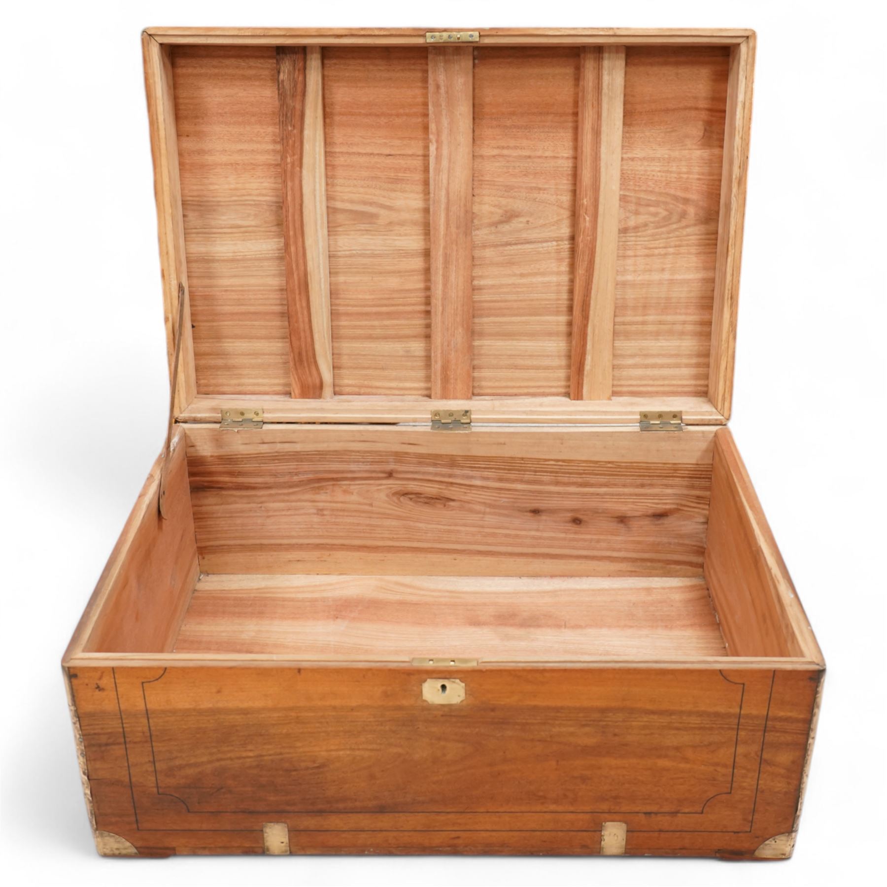 19th century camphor wood and brass mounted campaign chest, hinged lid with recessed brass handle enclosing vacant interior, mounted by brass edging and bands 