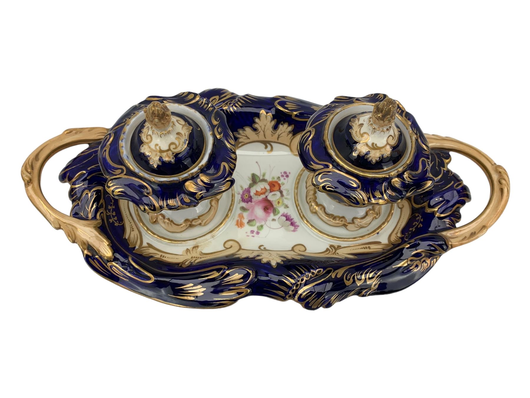 19th century porcelain inkstand, the oblong twin handled base centrally painted with a floral bouquet, flanked by two footed inkwells and covers, with rococo-inspired acanthus moulded borders and handles, pattern no. 2/3339, L26.5cm 