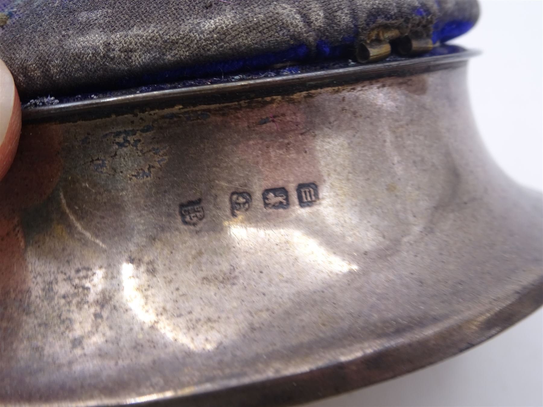 Group of silver, comprising silver mounted trinket box with pin cushion lid, bottle coaster with turned wooden centre, napkin ring, fish trinket box and a small 800 silver model of a boat, all stamped or hallmarked 