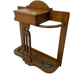 Arts & Crafts period golden oak hallstand, central glove compartment with moulded hinged top, over a Gothic pierced splat, flanking curved umbrella or stick stands