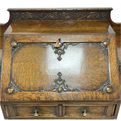 Early 20th century heavily carved oak bookcase bureau, raised back with grape-vine carved frieze, over fall-front enclosing fitted interior, above two short drawers and curved frieze drawer, flanked by astragal glazed and panelled cupboards, on turned feet