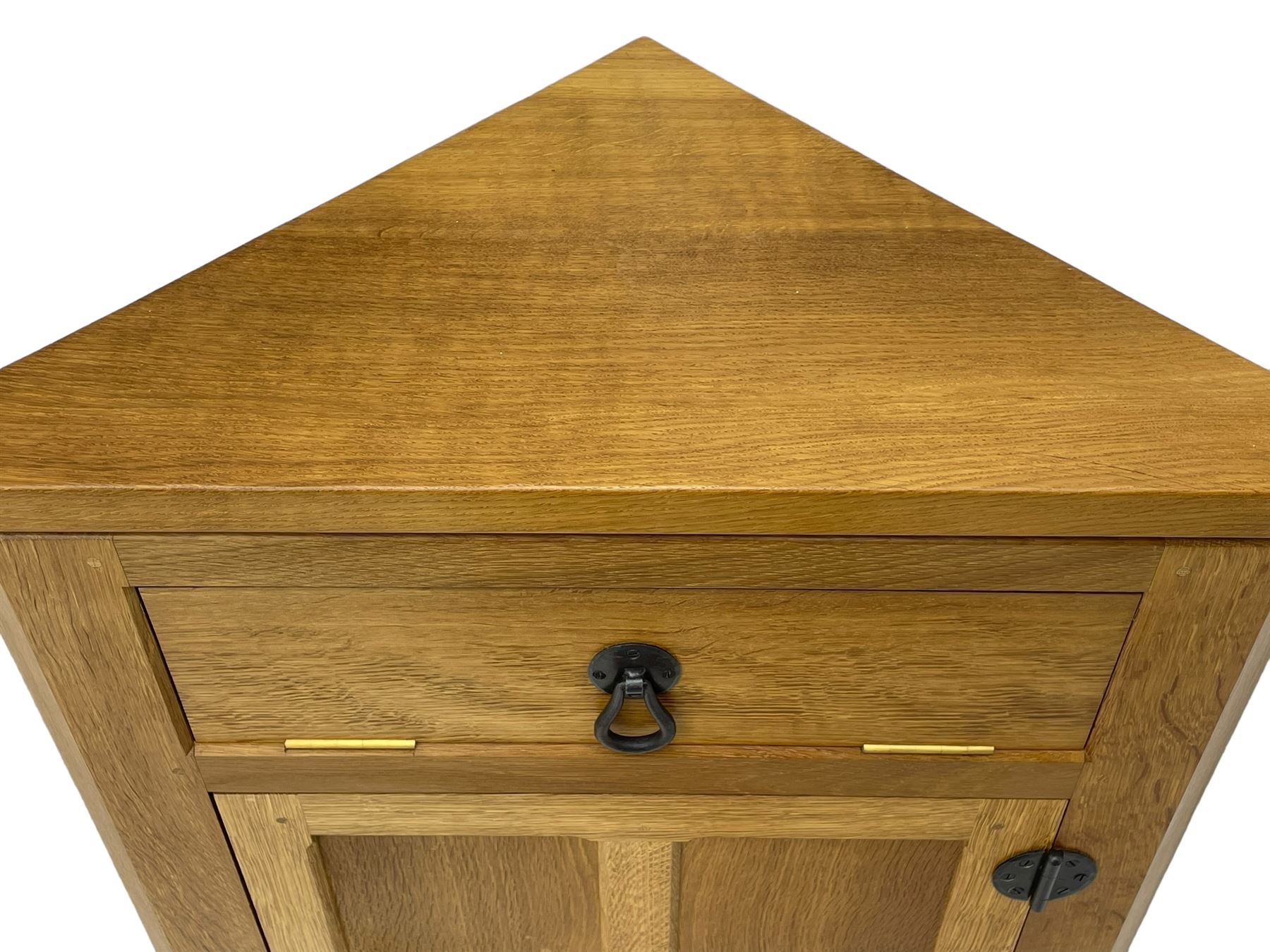 Mouseman - oak floor standing corner cupboard, fall front compartment over single panelled door, with wrought metal loop handle and latch, on moulded plinth base, carved in relief with mouse signature, by the workshop of Robert Thompson, Kilburn 