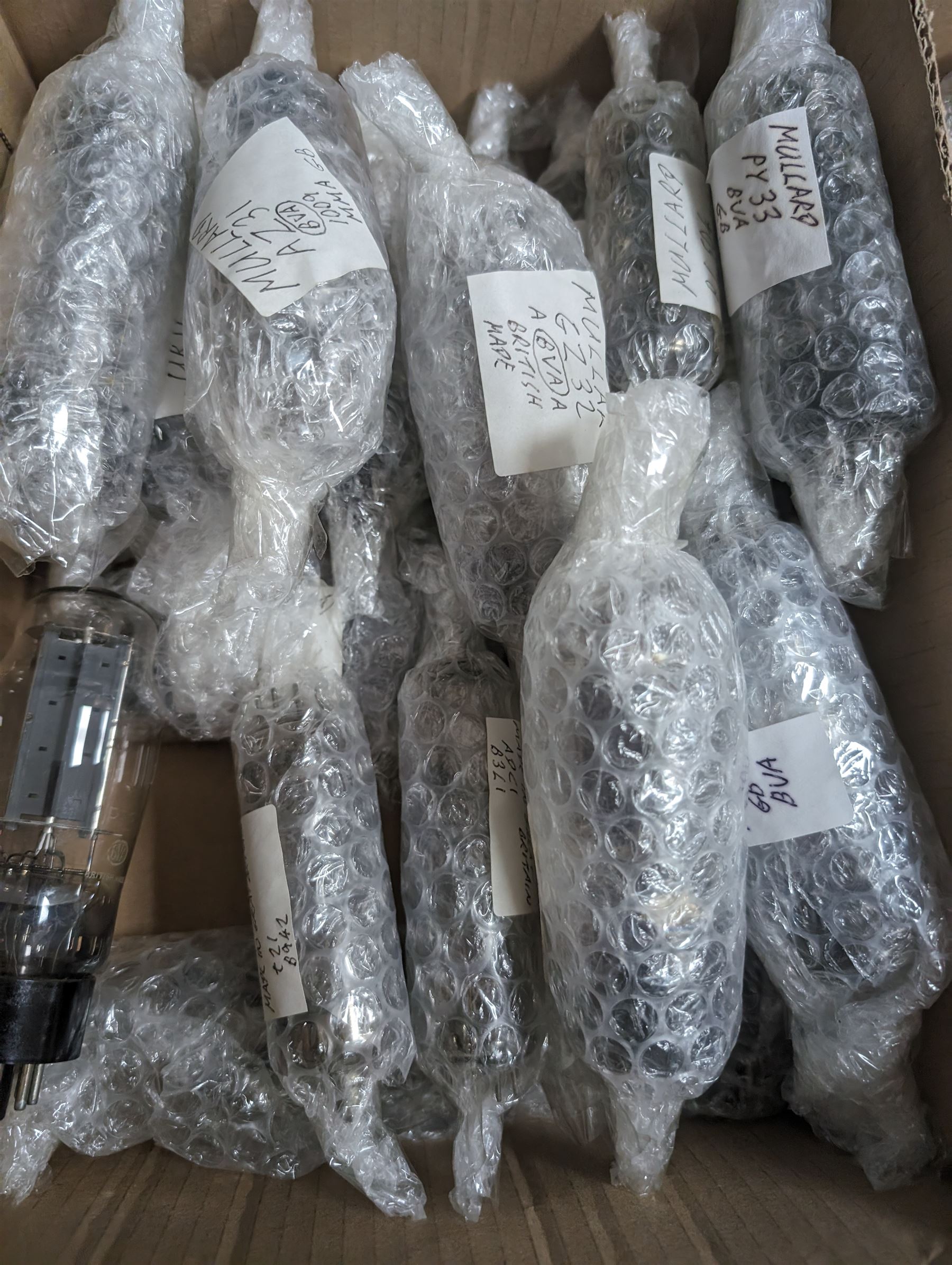 Collection of Mullard thermionic radio valves/vacuum tubes, mostly bubble wrapped and identified with lists