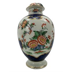 18th century Worcester tea caddy, of oval form and painted in the Kakiemon palette with reserves of flowers against a blue scale ground, H14cm together with a similar Worcester circular dish, painted with floral sprays, within a scalloped edge, blue crescent mark beneath, D19cm (2)