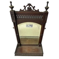 Early 20th century mahogany hall mirror with shelf, pierced pediment flanked by turned finials, the bevelled mirror plate enclosed by turned upright pillars, the shelf with fret work gallery, pierced lattice work lower panel 