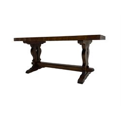 Solid oak coffee table, rectangular waved cut top with tooled ends, on shaped and pierced end supports joined by pegged stretcher 