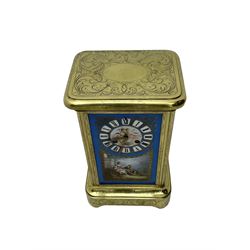 French - late 19th century 8-day mantle clock in an engraved brass corniche case with three rectangular porcelain panels decorated in the romantic Sevres style, dial with brass hands, cartouche Roman numerals and a depiction of cupid to the dial centre, rack striking movement sounding the hours and half hours on a bell. With pendulum.