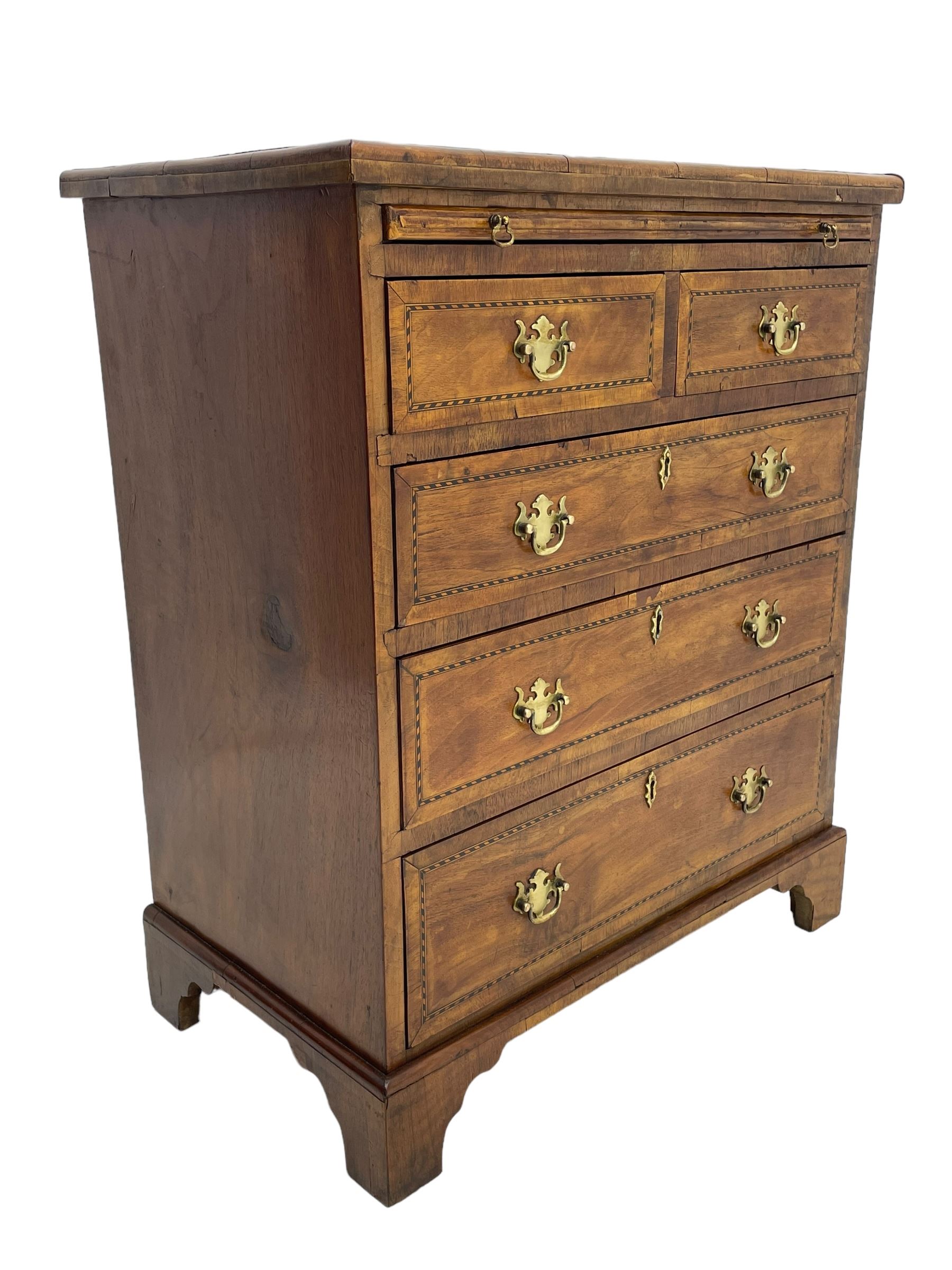 Small Georgian design walnut chest, moulded rectangular top with book-matched veneer enclosed by checkered stringing and crossbanding, brushing slide over two short and three long drawer, on bracket feet