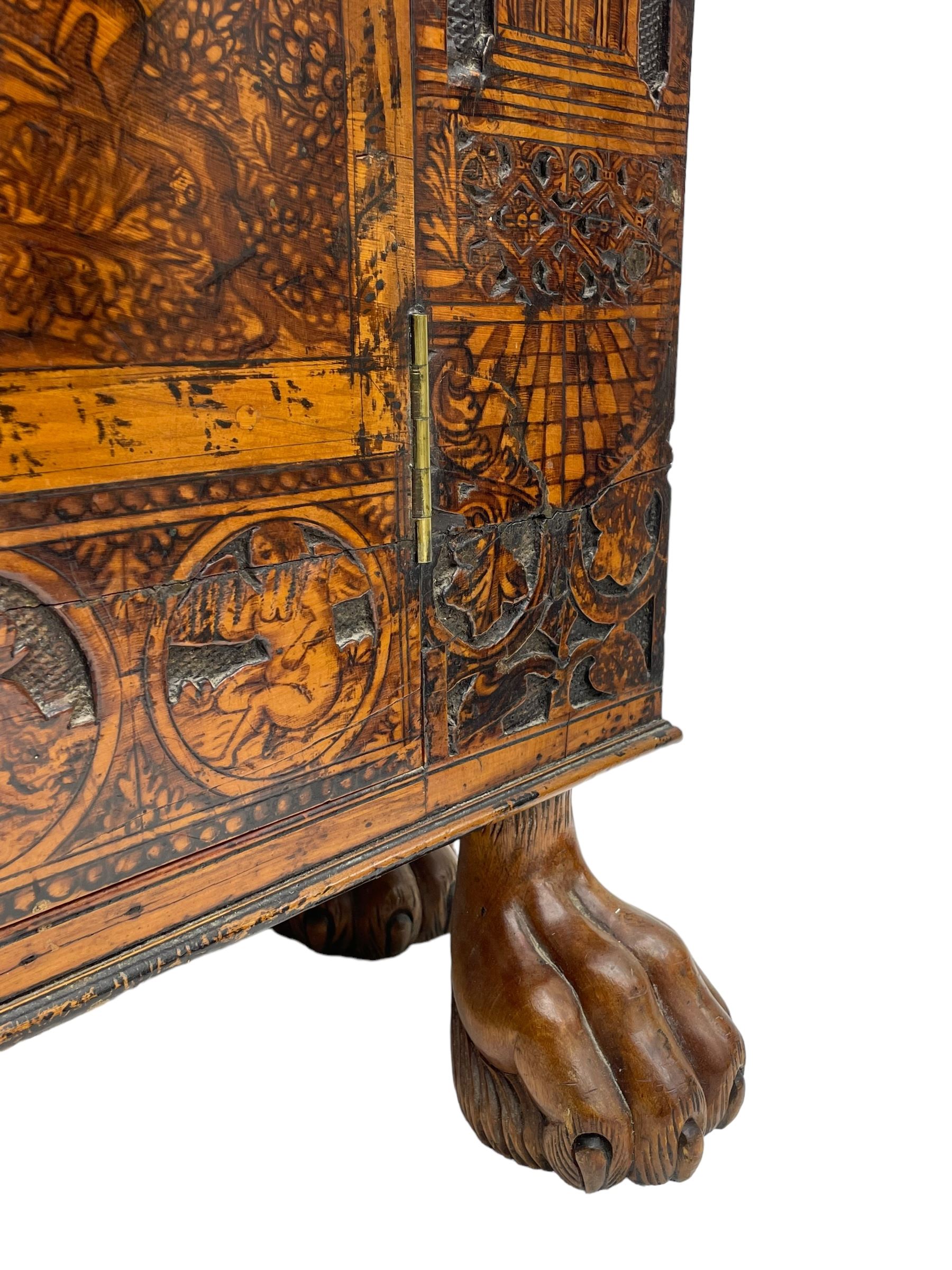 17th century and later cedarwood and pine side cupboard, moulded rectangular top, enclosed by two doors possibly removed and reused from a Venetian Cassone, carved and decorated with penwork, the upper architectural arcade with busts of noblemen, the larger decoration depicting hunters on horseback within woodland landscape with various animals, central and flanking uprights decorated with classical female figures upon pedestals, lower roundels decorated with lion and putto motifs, overall foliate decoration, raised on five hairy paw carved feet, the interior fitted with shelf