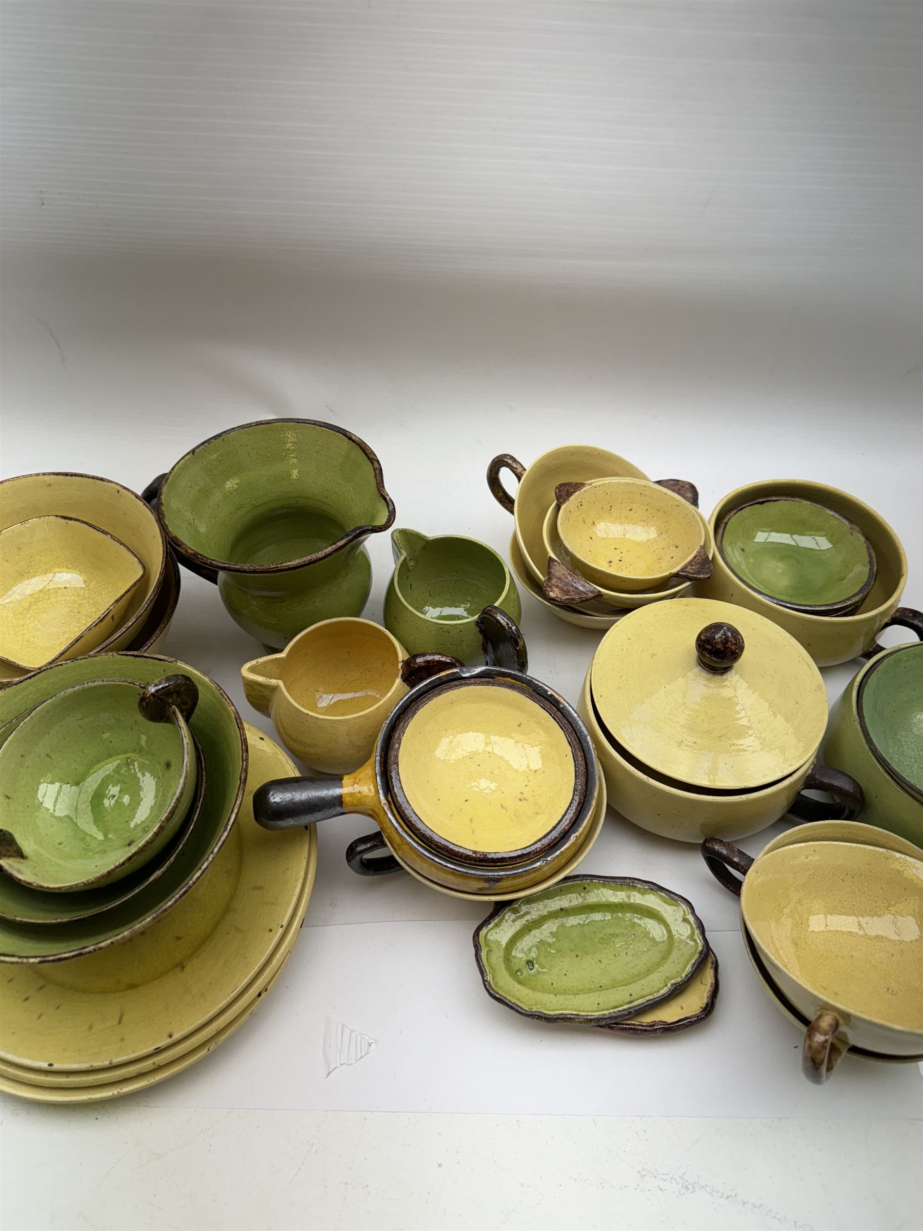 French green and yellow glazed tea and dinner wares by Etienne Noel, including milk jugs, teacups, side plates, bowls etc (43)