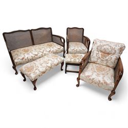 Early 20th century bergere lounge suite - two-seat sofa (W140cm, H80cm, D72cm); and pair of armchairs (W64cm); together with footstool, upholstered in floral fabric