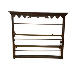 Two Victorian pine plate racks, one with scalloped cornice with central diamond shape and scroll ends over three shelves, the other with scalloped cornice, three shelves and fifteen hooks (2)