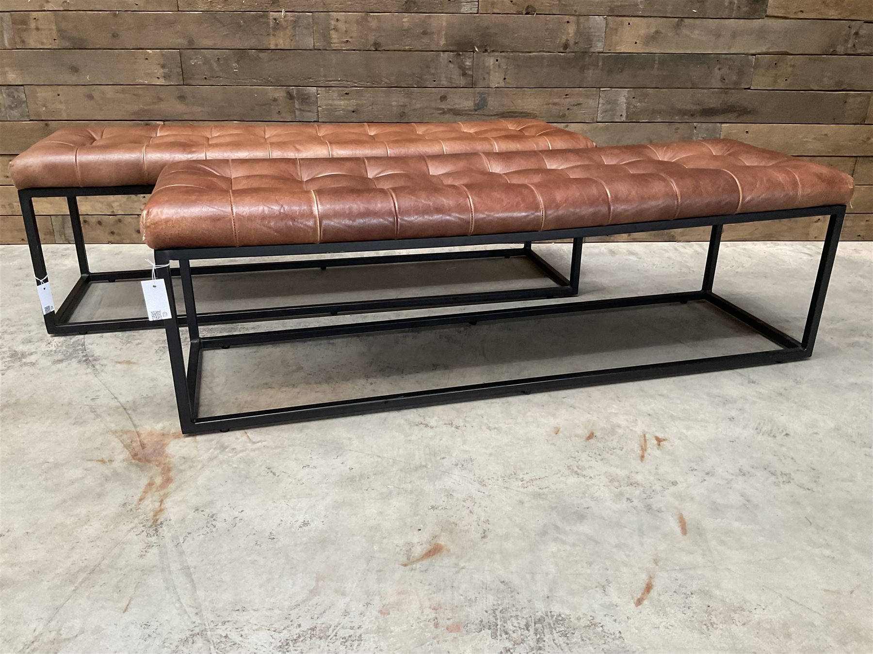 Two rectangular metal framed benches, upholstered in buttoned tan leather