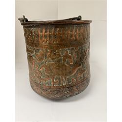 Middle eastern copper bucket, with chased and embossed band of animal decoration, together with a copper jardinière embossed with floral panels, copper plate with embossed leaf motif and two brass helmet shaped coal scuttles, bucket H26cm