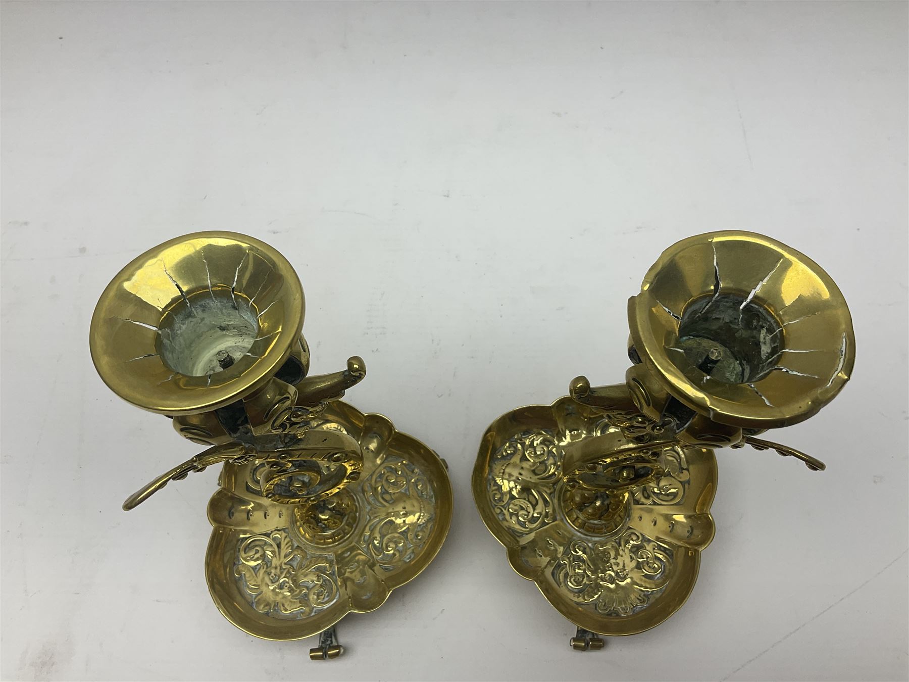 Pair of Victorian brass candlesticks by Adolf Frankau & Co, each with pierced sconce upon a scrolling stem with winged mask decoration, the lobed drip pan embossed with masks and upon three scrolling feet, stamped with maker's mark beneath, H18cm