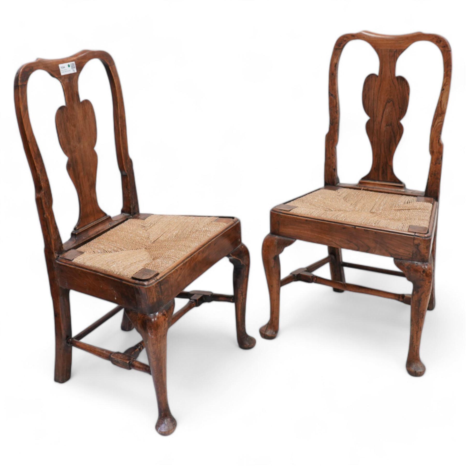 Pair of 18th century elm side chairs, shaped splat back over drop-in rush seat, on cabriole supports united by turned stretchers 