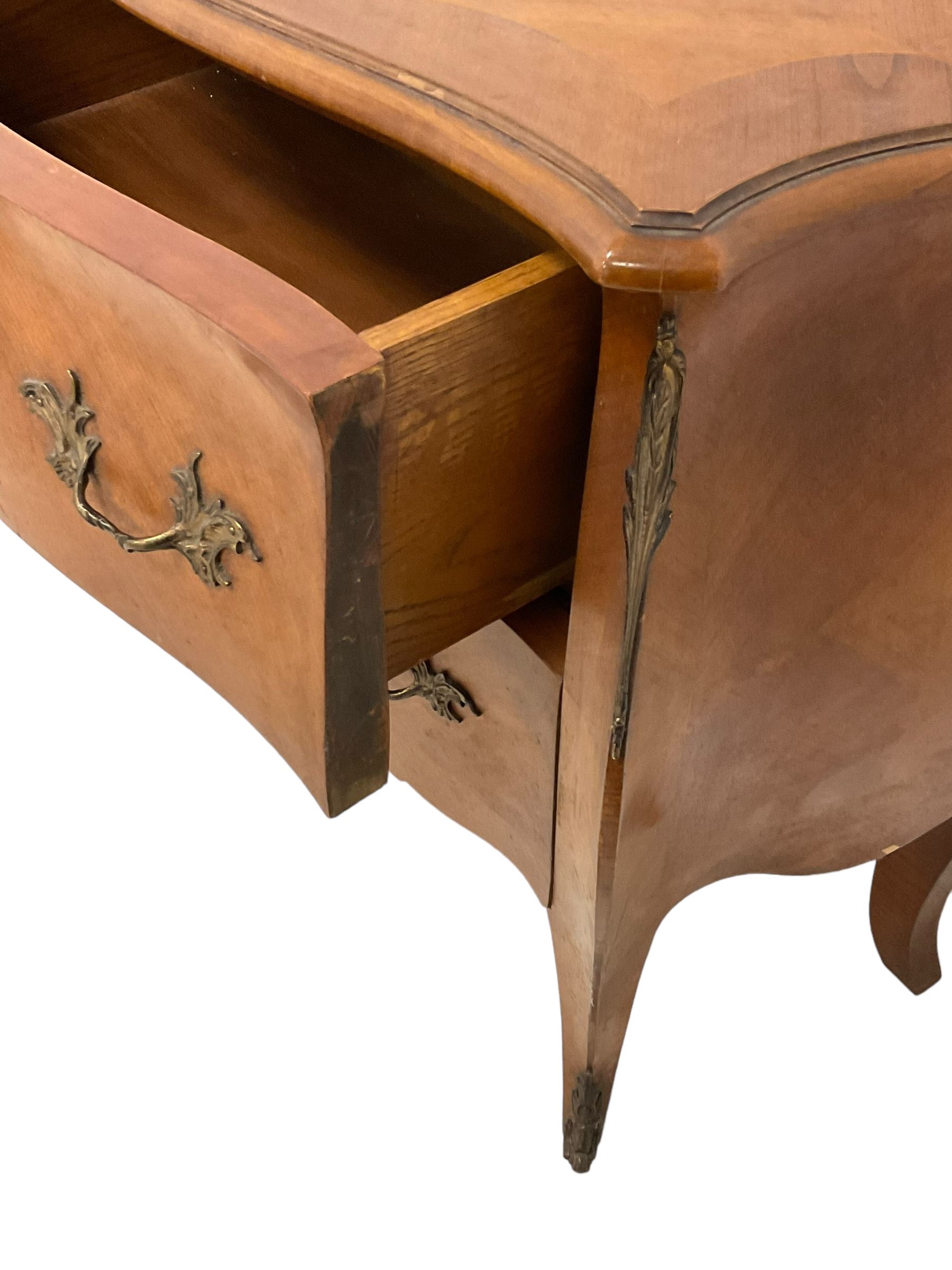 Late 20th century French design walnut bombe chest, shaped moulded top with quarter-matched veneers within crossbanding, fitted with two drawers with foliate cast metal handles and escutcheons, on tapering supports with ornate cast caps 