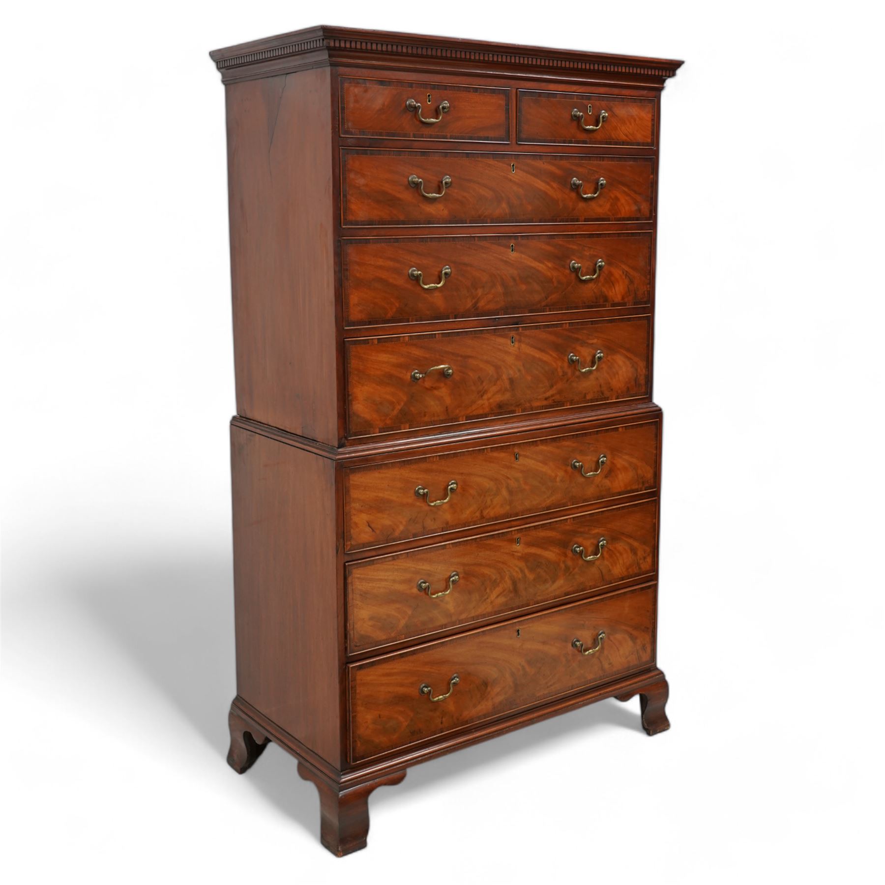 George III mahogany chest-on-chest, projecting moulded and dentil cornice, fitted with two short over six long graduating cock-beaded drawers, each with mahogany band and checkered stringing, brass swan neck handles and circular plates, on ogee bracket feet