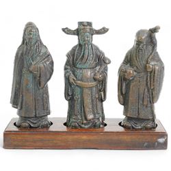 Set of three Chinese bronze deities, on a rectangular hardwood stand, L13cm