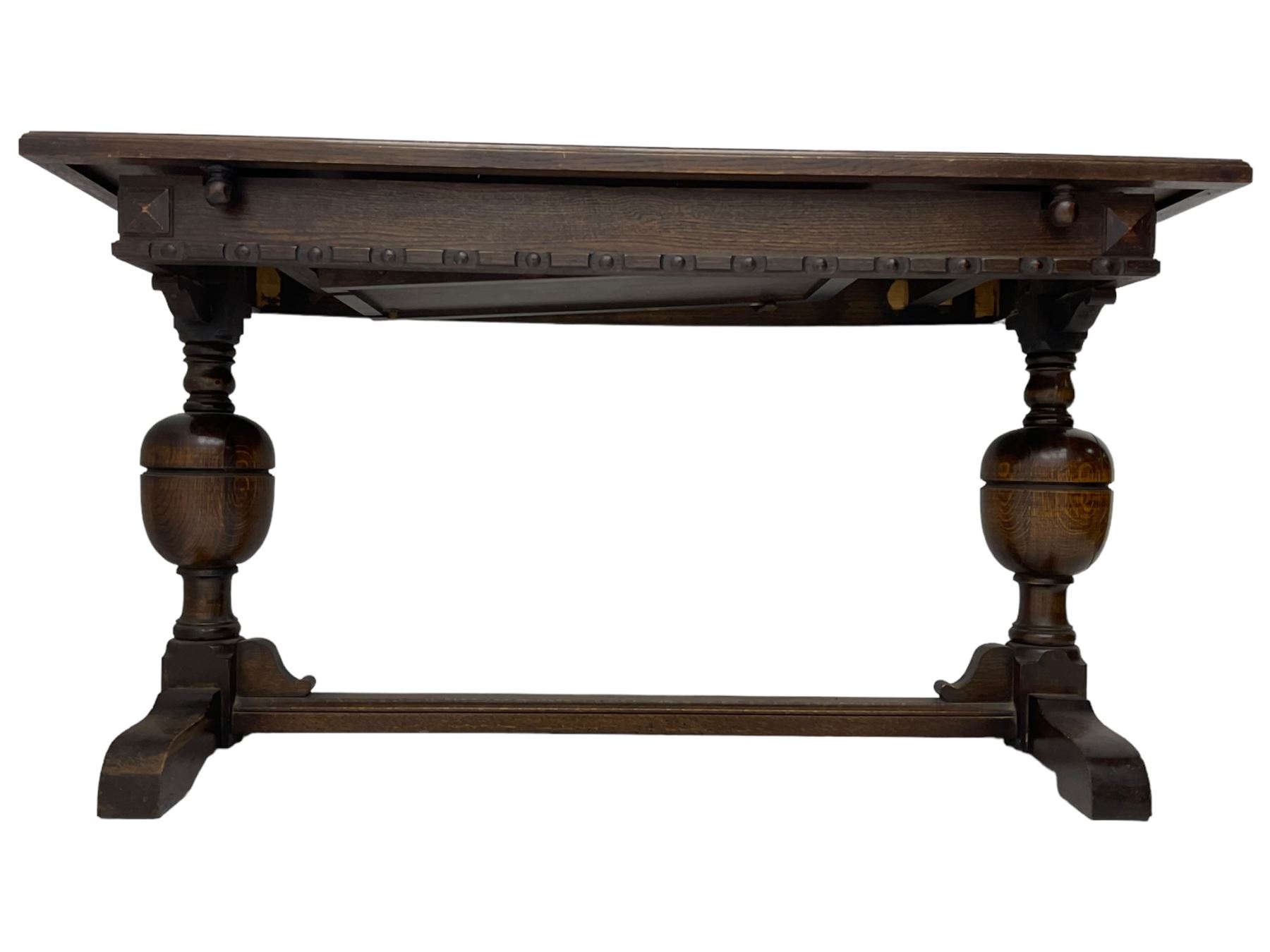 Early 20th century oak extending table, moulded rectangular top, pull-out action with fold-out leaf, on turned cup and cover pedestals and sledge feet, united by moulded stretcher 