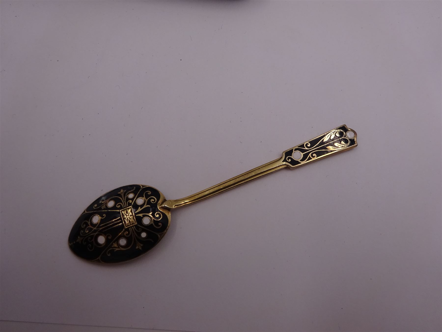 Set of six 1930s silver-gilt and enamel coffee spoons, the bowls and finials decorated verso in black and white enamel, hallmarked Turner & Simpson Ltd, Birmingham 1933, contained within fitted case