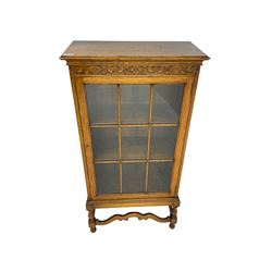 Early 20th century oak bookcase display cabinet, enclosed by single glazed door, on turned supports with shaped front stretcher rail