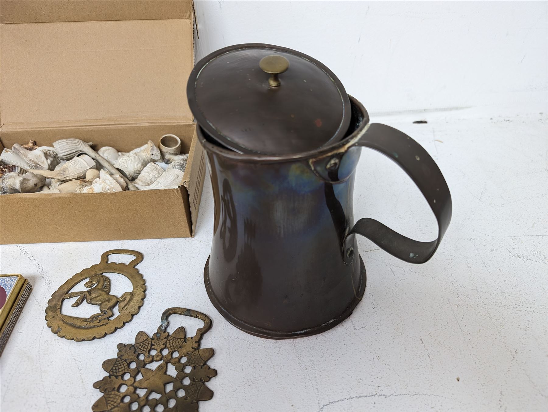 Collection of clay pipes, serval carved as faces, together with butter presses, copper tankard, torpedo glass bottles etc 