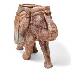 Early 20th century Indian hardwood and polychrome Elephant jardiniere stand, decorated with a headdress and vibrant saddle cloths, surmounted by an octagonal shaped saddle, with overall craquelure finish