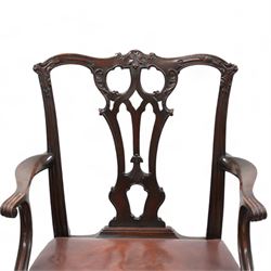 Early 20th century pair of Chippendale design mahogany elbow chairs, shaped cresting rail carved with foliate cartouches and scrolled leaves, pierced and interlaced Gothic splat, shaped arms with scroll carved terminals, leather upholstered seat with stud band, cartouche carved cabriole supports with ball and claw feet 