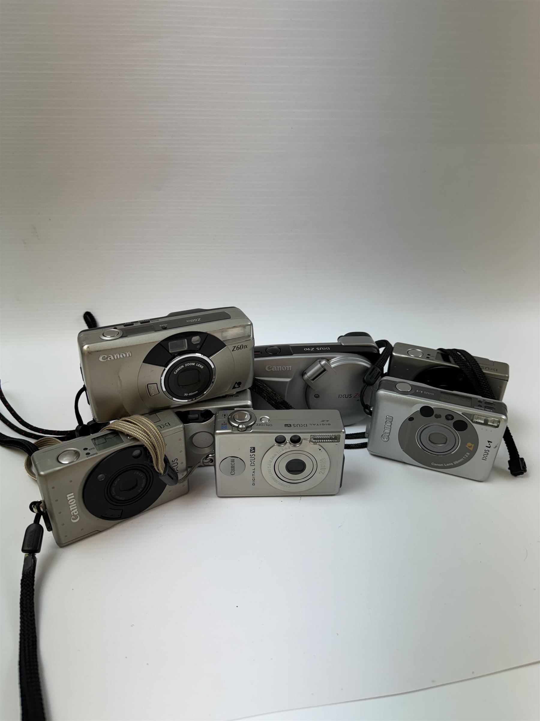 Eight Canon compact Ixus cameras, to include two Ixus examples serial nos. 2309147 & 2273184, Ixus M-1 serial no. 2932566, Ixus L-1 serial no. 2161988, Ixus Z90 serial no. 2201833,  Ixus X-1 serial no. 4704380, Z60IX serial no. 7474817, Ixus V2 serial no. 4431003237 and a Canon Powershot 350 digital camera serial no. H7MX00941