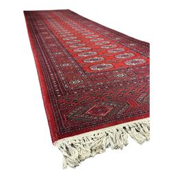 Persian Bokhara crimson ground runner rug, the field with a series of repeating ivory octagonal medallions, main border with repeating flower head pattern and diamonds within multiple guard stripes