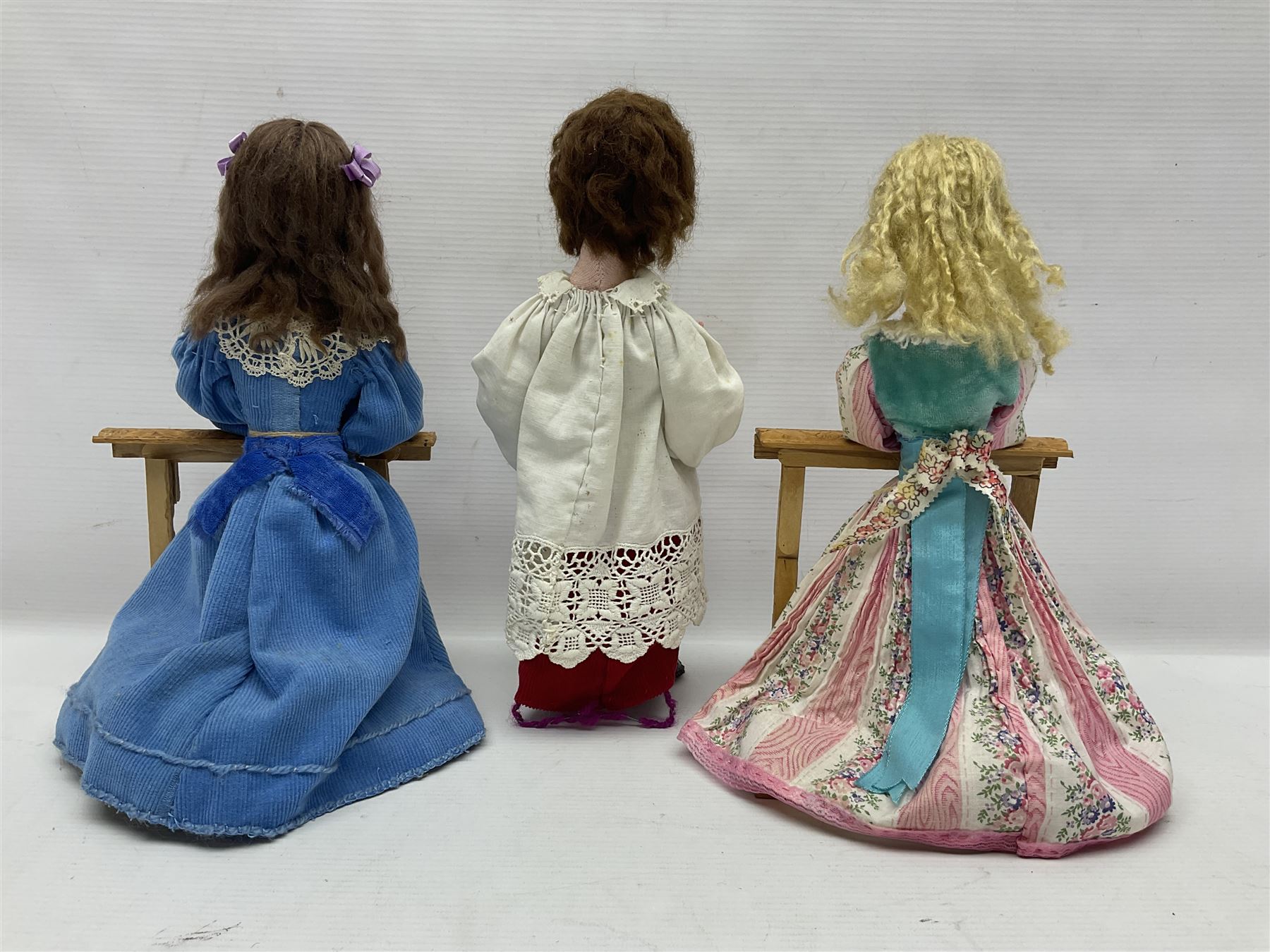 Anna Meszaros Hungary - two hand made needlework figurines, each of a young girl kneeling by an alter rail praying H28cm; together with another similar of a chorister H29cm (3)  Auctioneer's Note: Anna Meszaros came to England from her native Hungary in 1959 to marry an English businessman she met while demonstrating her art at the 1958 Brussels Exhibition. Shortly before she left for England she was awarded the title of Folk Artist Master by the Hungarian Government. Anna was a gifted painter of mainly portraits and sculptress before starting to make her figurines which are completely hand made and unique, each with a character and expression of its own. The hands, feet and face are sculptured by layering the material and pulling the features into place with needle and thread. She died in Hull in 1998.