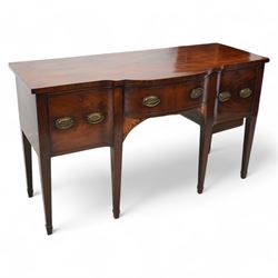 George III mahogany break bow-front sideboard, fitted with three drawers, the corner brackets inlaid with quarter shell motifs, pressed brass oval handle plates decorated with oak leaves and acorns, on square tapering supports