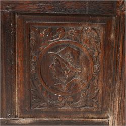 18th century carved oak coffer or chest, sloped hinged lid over panelled front, carved with three Northern European portraits with foliage surrounds decorated with birds, fitted with wrought metal carrying handles, on fluted stile supports 