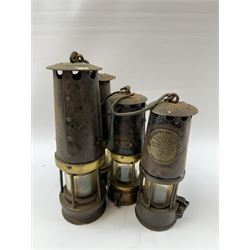 Four miners lamps, including Eccles Manchester example, tallest H30cm