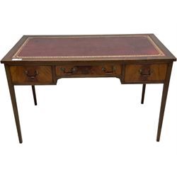 Mid-to-late 20th century mahogany writing desk, the rectangular top with a tooled red leather insert bordered with gilt detailing, three cock-beaded drawers with brass handles, the narrow central drawer flanked by two wider drawers, standing on square tapered legs