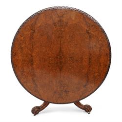 Victorian figured walnut breakfast or centre table, circular tilt-top with carved edge and quarter-matched veneers, turned pedestal with foliate carved baluster on three out splayed supports decorated with floral carvings and scrolled terminals, on brass castors 