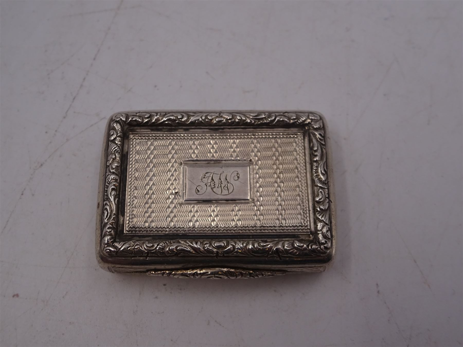 William IV silver vinaigrette, of rectangular form, with engine turned decoration throughout, chased scrolling borders and engraved cartouche to hinged cover, opening to reveal gilt interior with typical pierced cover, hallmarked Charles Reily & George Storer, London 1834, W3.7cm