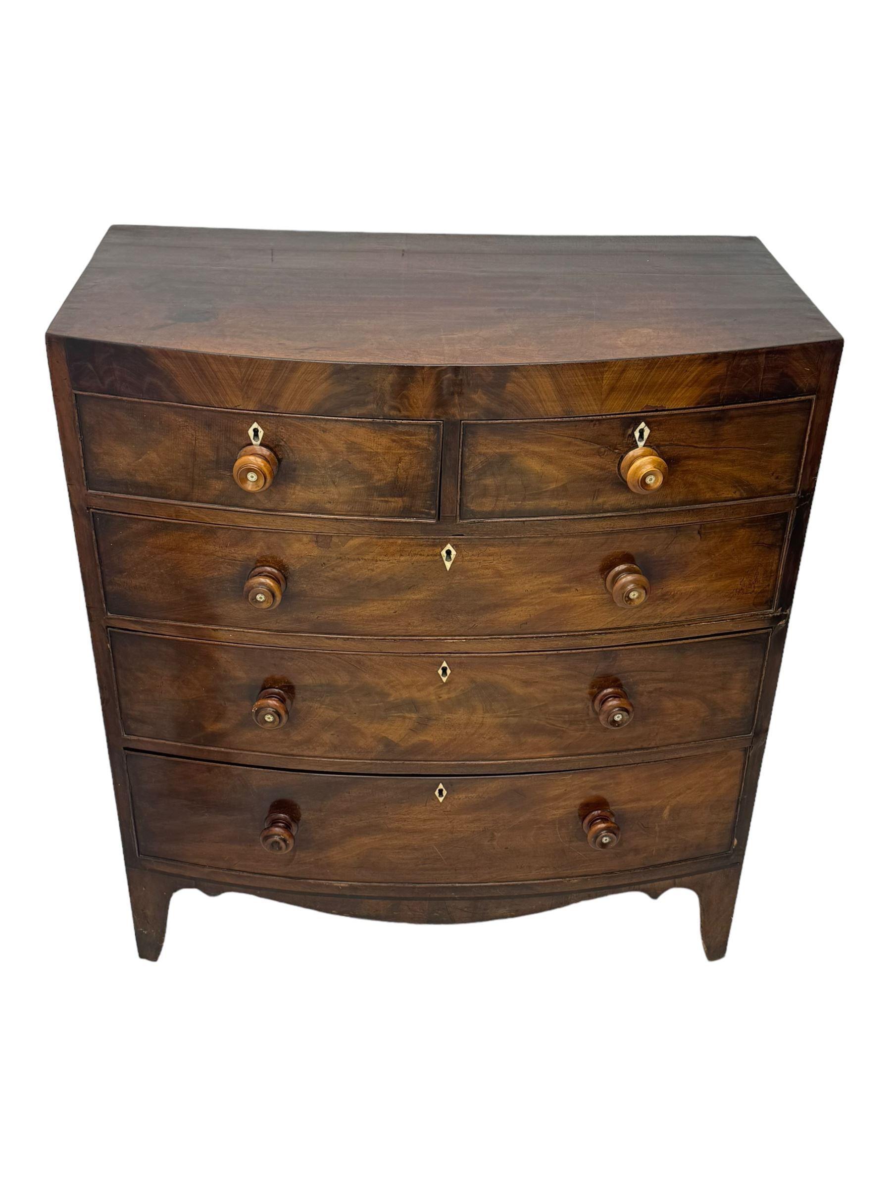 Early 19th century mahogany bow-front chest, fitted with two short over three long graduated cockbeaded drawers, each with turned wooden knobs and bone escutcheon, raised on splayed bracket supports