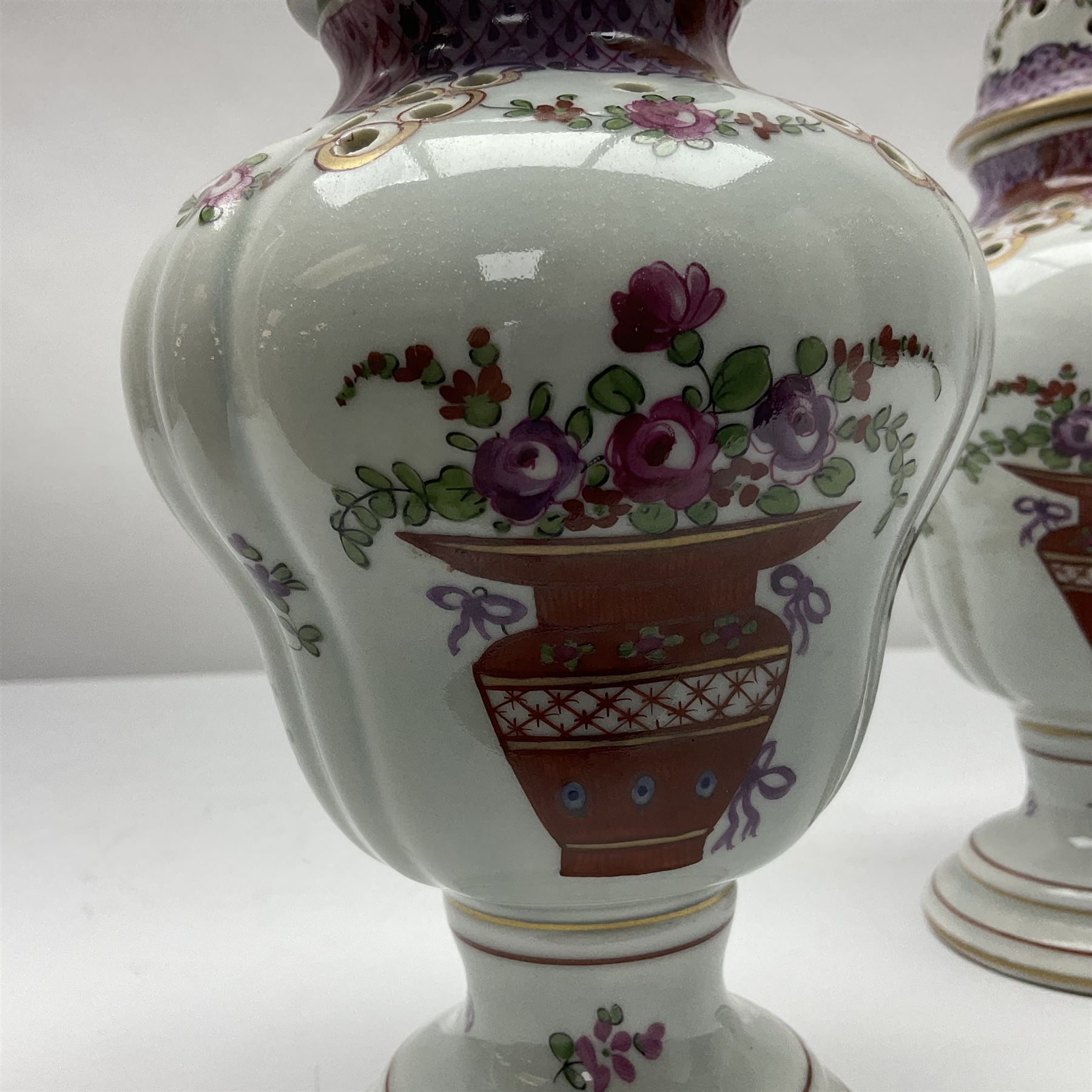 Pair of pot pourri vases and covers, decorated with floral sprigs and with rose finials to the covers, H24cm