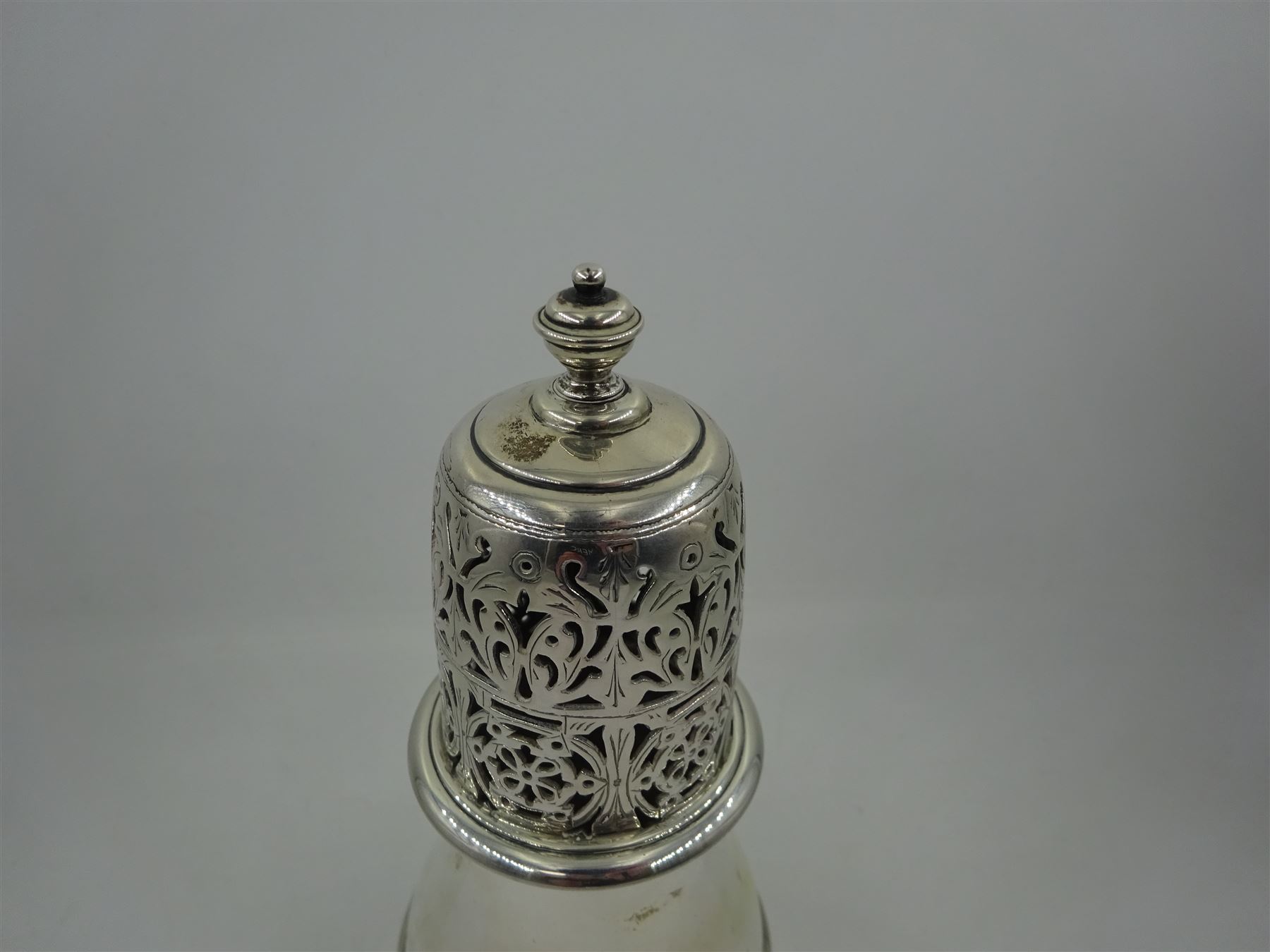 1920s silver sugar caster, of typical waisted form, the removable pierced floral cover with urn finial, hallmarked Charles Perry & Co, Chester 1929, H17cm