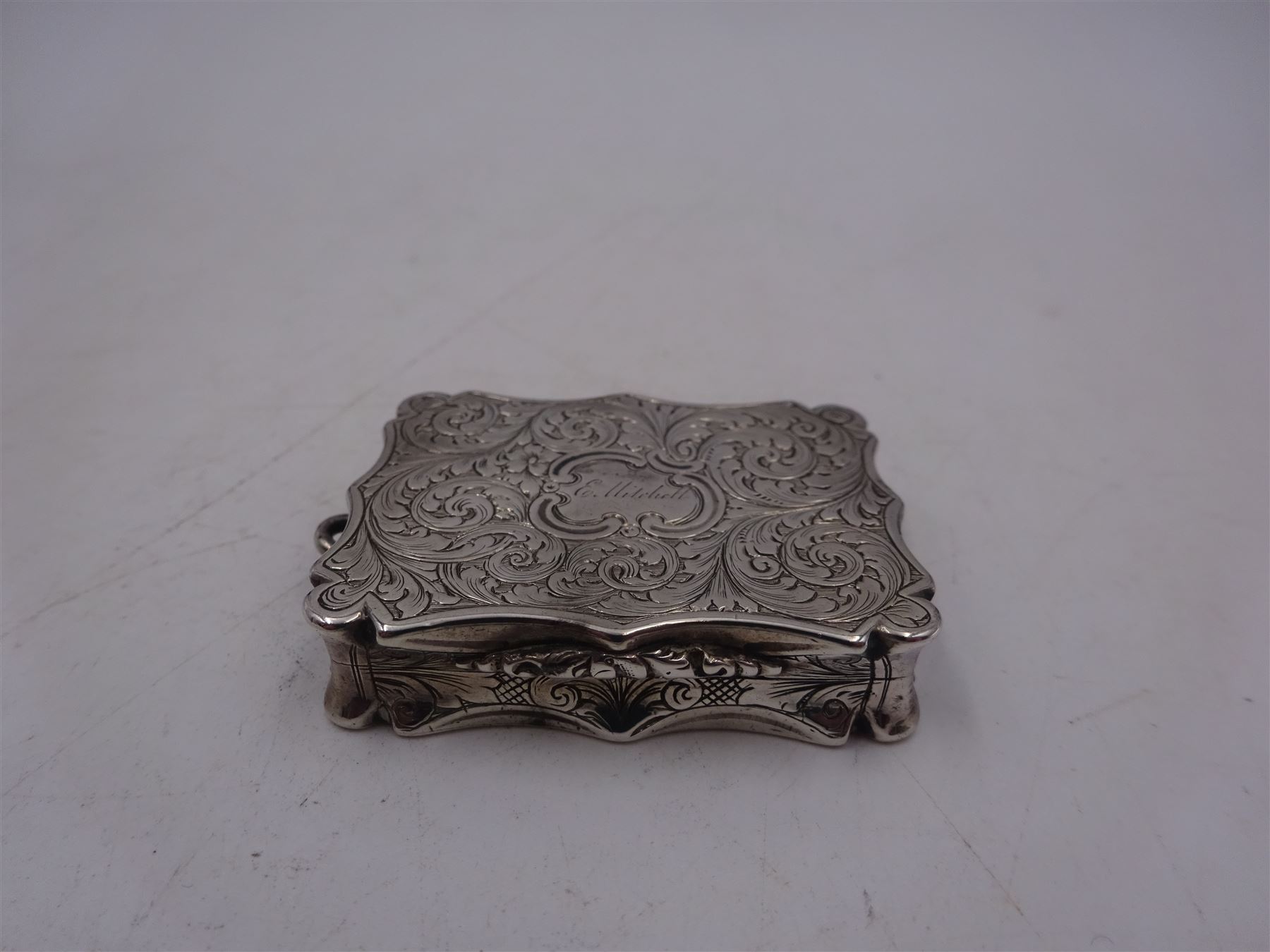 Victorian silver vinaigrette, with bright cut scrolling decoration and engraved name to hinged cover, the gilt interior with typical pierced cover, hallmarked Nathaniel Mills, Birmingham 1848, W4.2cm