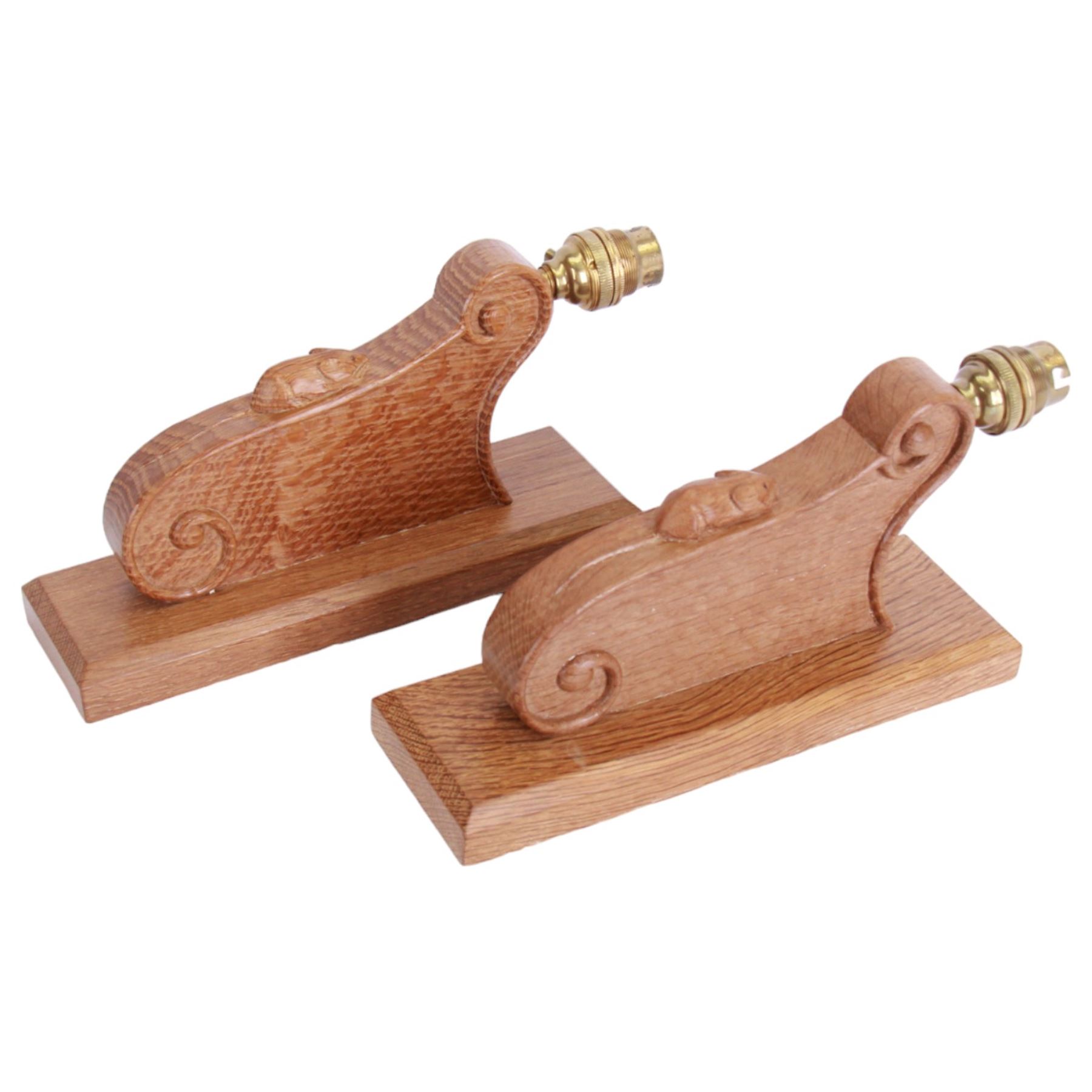 'Mouseman' pair of carved oak wall lights or sconces, scrolled decoration on chamfered rectangular mount, carved with mouse signature, with fittings and shades, by Robert Thompson of Kilburn