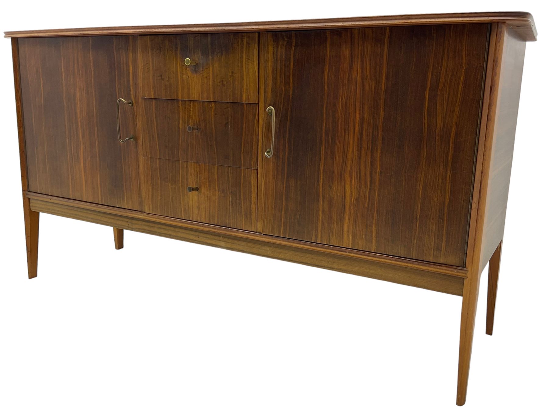 Mid 20th century teak sideboard, rectangular top with rounded corners over three central drawers, flanked by two cupboard doors enclosing shelves, raised on tapered supports