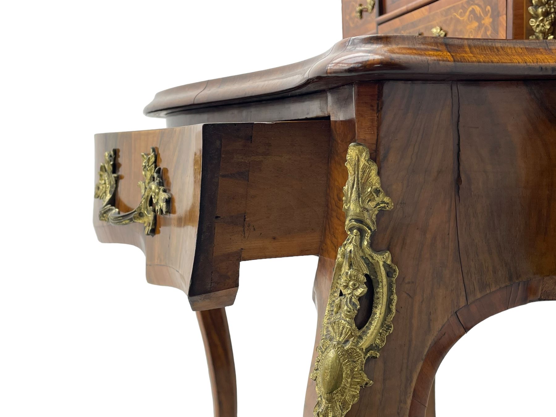 19th century French figured walnut Bonheur de Jour or writing desk, the upper section with brass gallery over mirror glazed cupboard and a combination of drawers, shaped and moulded top with leather inset and satinwood band, fitted with single drawer, on cabriole supports, inlaid throughout with scrolling foliate decoration in boxwood, ornate cast brass mounts 