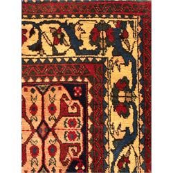 South West Persian Abadeh crimson ground rug, indigo ground with crimson lozenge field, decorated all over with small stylised motifs of flowerheads, hooks, animals and birds, guarded border decorated with trailing leaves and stylised plant motifs 