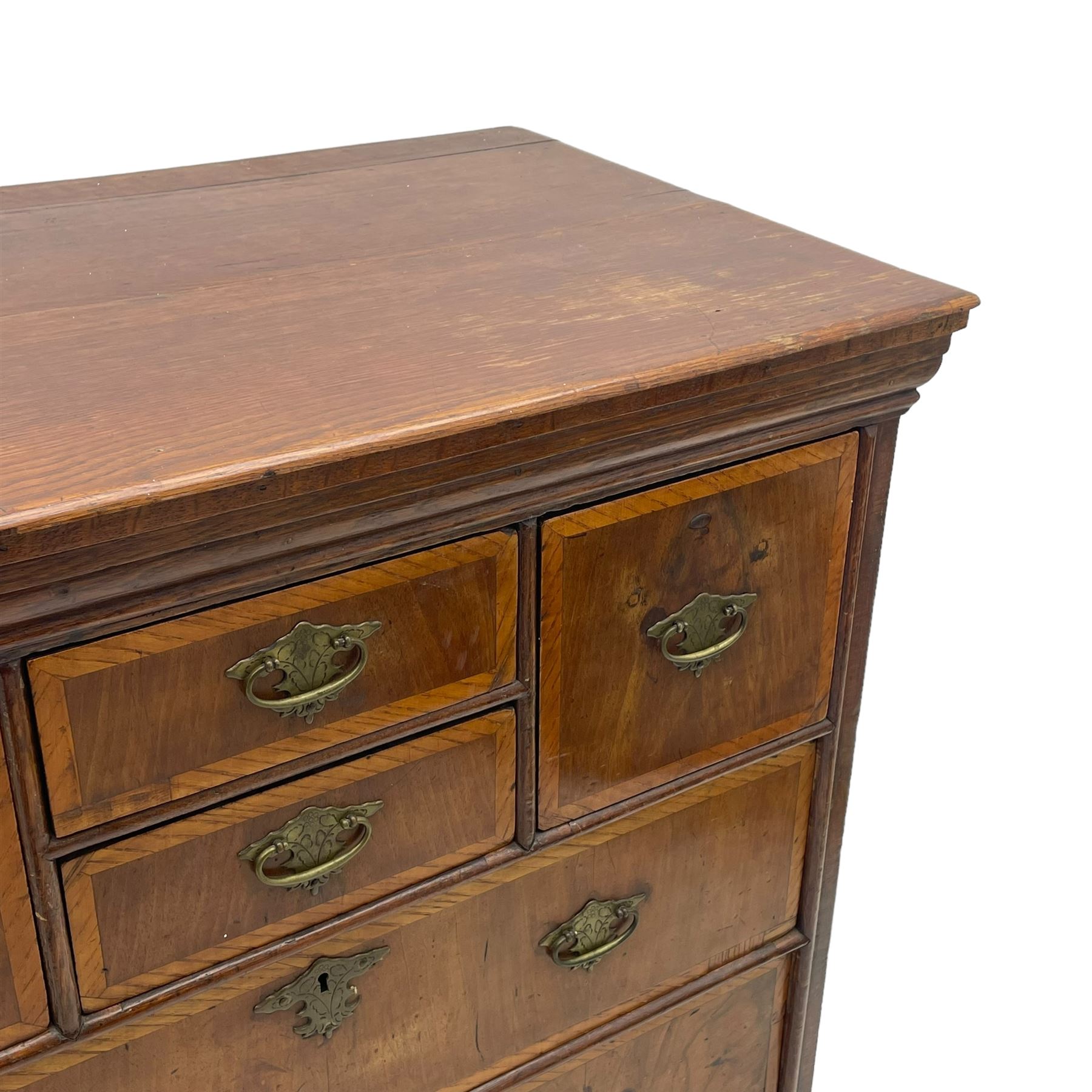 18th century oak and walnut chest, fitted with four small over three long drawers with figured walnut facias, brass handles and plates with engraved decoration, on bracket feet