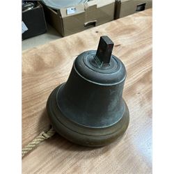 Late 19th century/early 20th century bell with rope pull, probably a fire bell, marked LCC G49 to canon, upon a black painted wrought iron wall mount, bell H29cm, mount H64cm