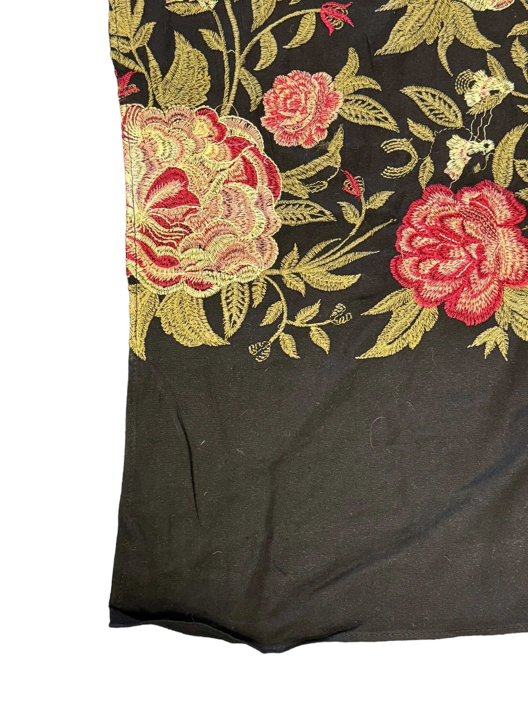 Embroidered Karandi fabric runner, the field featuring a black ground with an all-over floral design, including large pink and cream roses, accompanied by green leaves and small blossoms, bordered by plain sections at each end