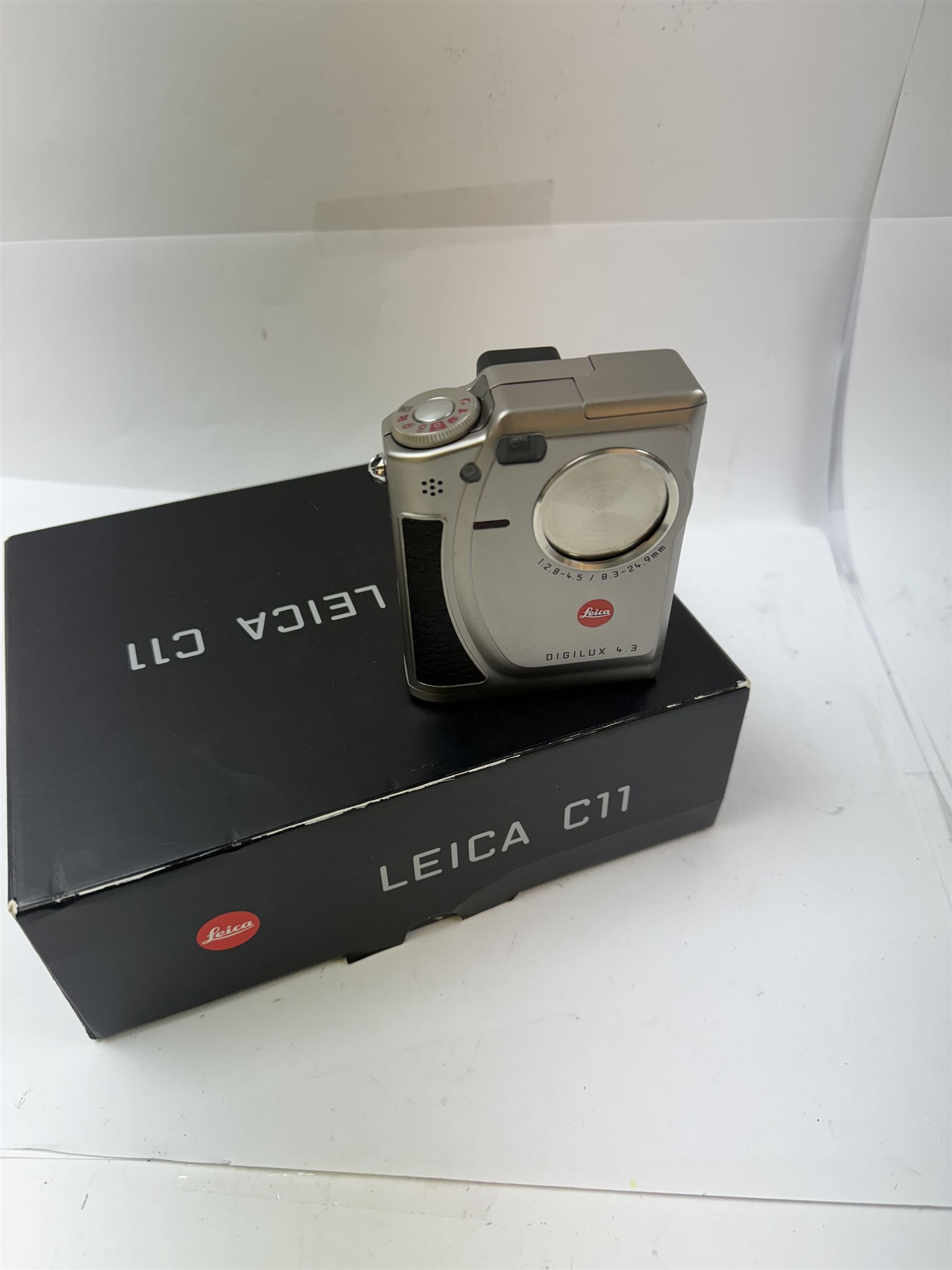 Leica C11 APS film compact camera, in silver and chrome finish, serial no. 2636834, in original clear hard case and box, with instruction booklet, together with a Leica Digilux 4.3, with 1:2.8-4.5/8.3-24.9mm lens, serial no. 2598862, with instruction booklet